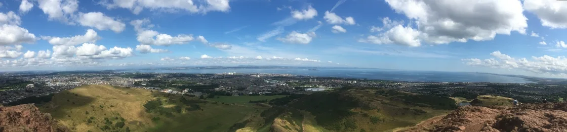 The view from Arthur&rsquo;s Seat over Edinburgh, with Holyrood Park in the foreground and the city stretching to the Firth of Forth and the Fife coast